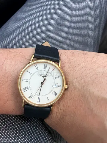 Classic gold-tone mens wristwatch with black leather strap