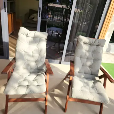 Pair of wooden reclining patio chairs with cushions