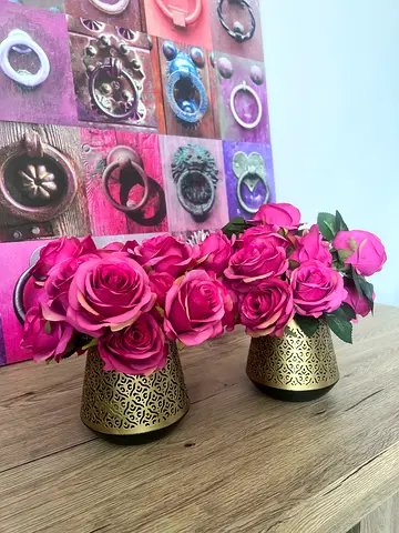 Set of two decorative gold vases with pink artificial roses