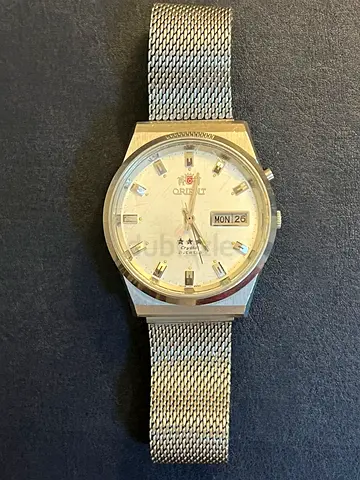 vintage Orient TriStar 3-Star Crystal automatic watch with a white dial and mesh bracelet