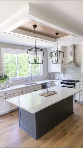 Modern kitchen island with pendant lighting — gray island, white quartz top