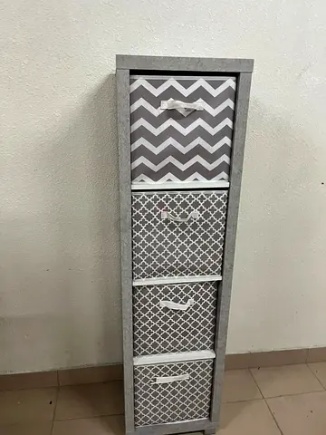 This gray wooden storage unit from Home Source features fold-down fabric drawers.