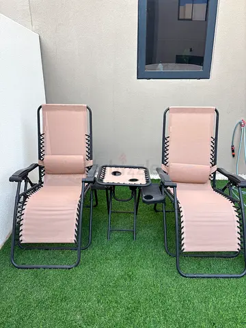 Pair of outdoor reclining lounge chairs with side table