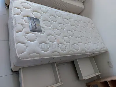 Bed base with a single White Mattress and a bedside table in Good Condition
