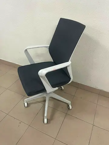 A gray office chair with a white frame and mesh back design.