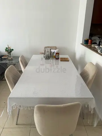 Dining table with 5 upholstered chairs — light beige set in good condition