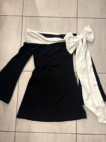 Black off-shoulder dress with white bow detail