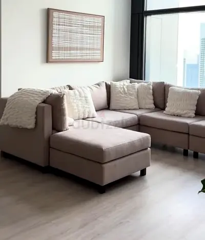 Light beige sectional sofa with ottoman - good condition. (Excludes pillows/blankets)