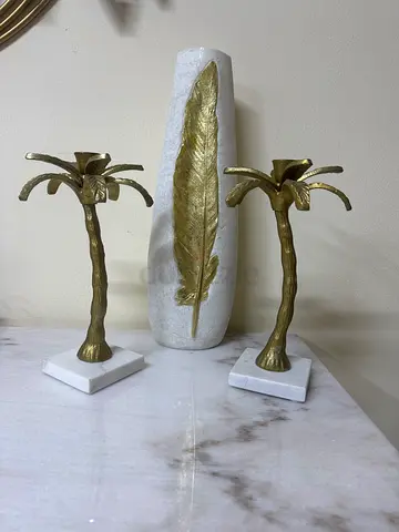 Pair of decorative brass palm tree candle holders on marble bases
