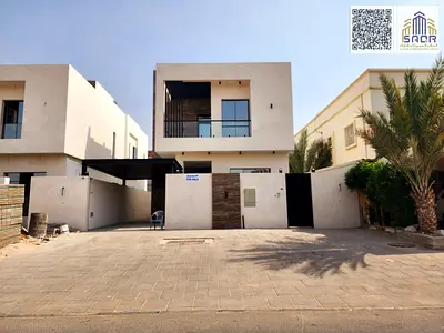 New villa in Al Muwaihat 2 for sale, directly next to the mosque, on a paved road, with a front setback of approximately 10 meters for outdoor parking.
