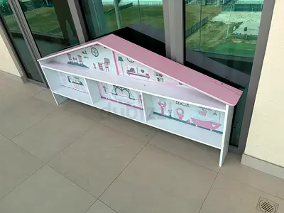 Low childrens storage shelf with dollhouse-themed back panel, white and pink