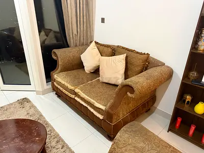 Two-seater ornate brown fabric sofa in good condition