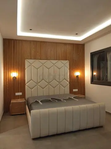 Queen upholstered bed with padded headboard and leather-look frame