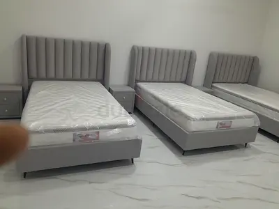 Three Single Grey Upholstered Beds with Headboards and Mattresses