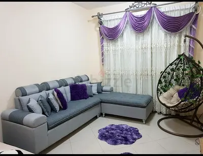 L-shaped grey fabric sofa with chaise lounge and cushions (good condition)