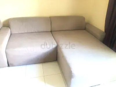 L-shaped beige fabric sectional sofa with ottoman - good condition
