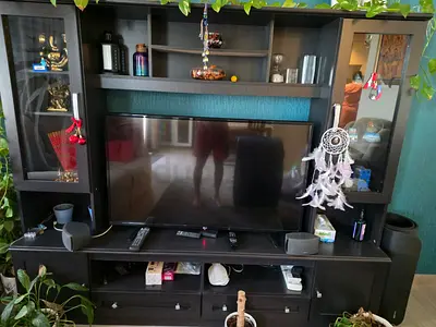 Dark wood entertainment center with shelves and glass cabinets