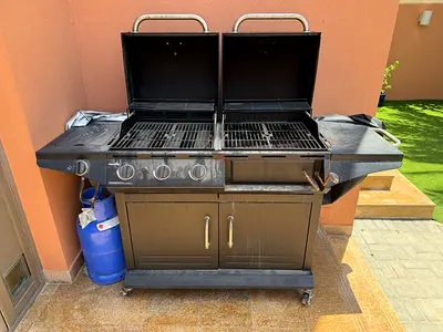 Large dual-lid gas BBQ grill with side burners and storage cabinet