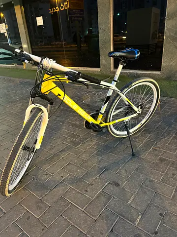 Used white  yellow city/commuter bicycle - front wheel shown, with kickstand