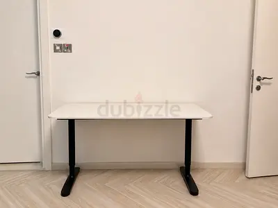 Height-adjustable white office desk with black legs
