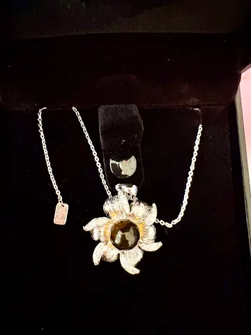Silver flower pendant necklace with black stone centerpiece