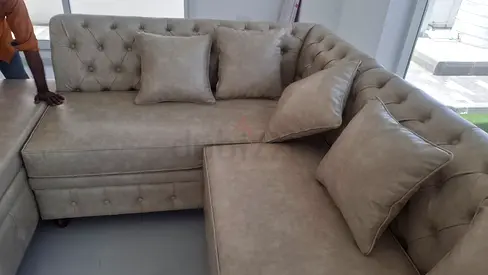 L-shaped tufted beige corner sofa with cushions couch