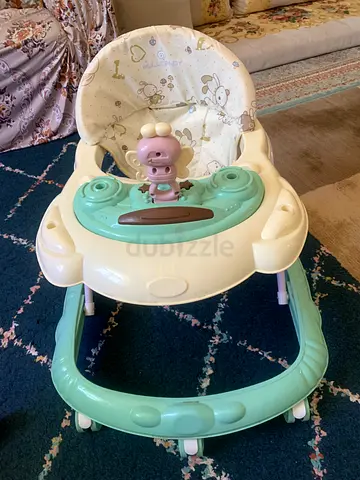 Green and white baby walker with toy tray — good condition