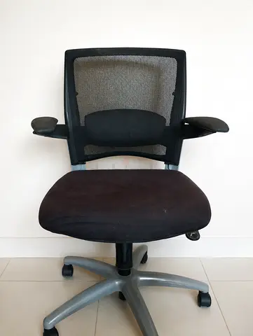 Black ergonomic office chair with mesh back and adjustable arms