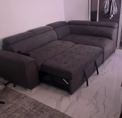 Dark grey L-shaped pull-out sofa bed with storage — good condition