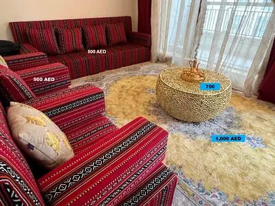 Majlis floor seating, large Persian-style rug, decorative coffee table, TV,  and Stand. - used.
