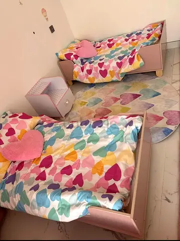 Pair of pink toddler beds with bedside table  heart-themed bedding. Memory form mattresses included
