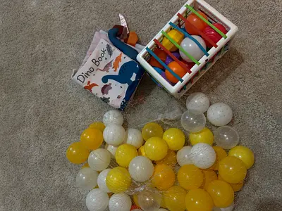 Baby playset: soft Dino book, rattle basket and 50 playpen balls (yellow/white)