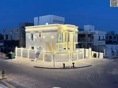 A corner villa for sale in Ajman, two floors and a roof, located on two streets with a large setbac