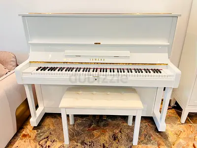 White upright piano in good condition with bench