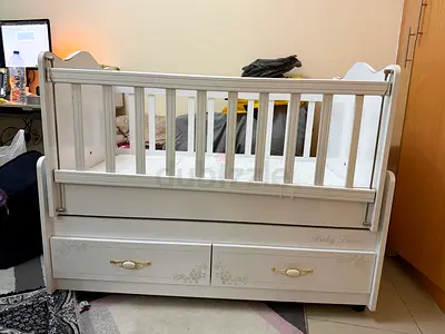 White wooden baby crib/bed/rocker with storage drawers - good condition