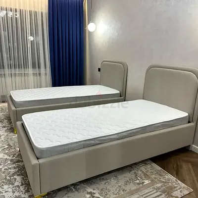 Pair of single upholstered beds with mattresses