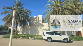 Two corner houses for sale in Al Ghafia. The first house has 4 bedrooms, a living room, a majlis, an