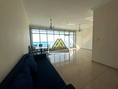 A 2-bedroom apartment with a living room for annual rent in Corniche Residence – Ajman, featuring a direct full sea view from the balcony, comfortable