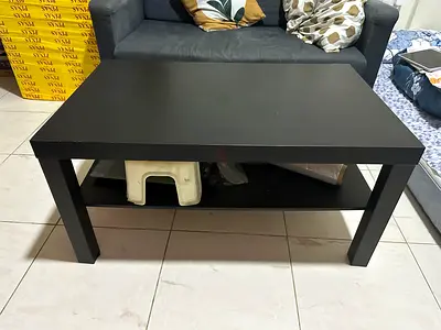 Used black rectangular coffee table with lower shelf