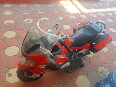 Red rechargeable kids ride-on motorcycle with storage boxes