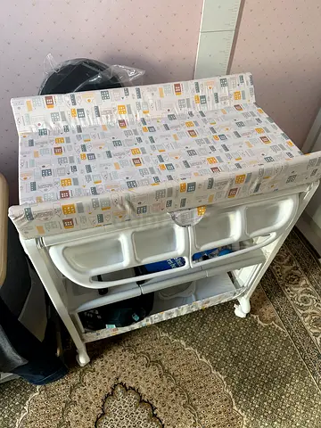 baby changing table with bath and  storage shelves - gently used