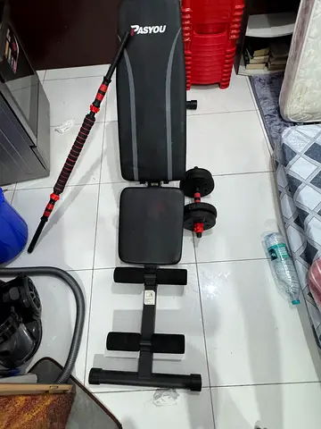 Adjustable workout bench with dumbbells and barbell curl attachment