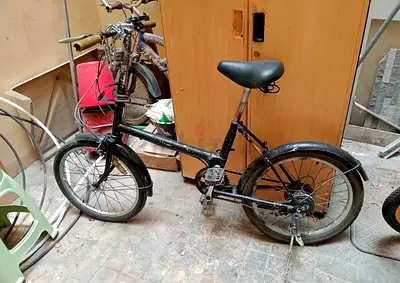 Used small black folding-style bicycle — needs cleaning and minor repairs