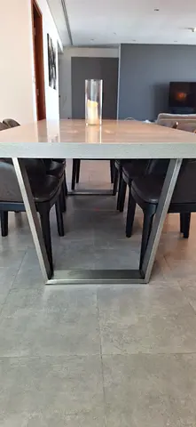 Modern dining table with 6 leather upholstered chairs, solid metal base, stone look top