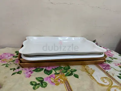 Set of white ceramic serving platters with wooden tray