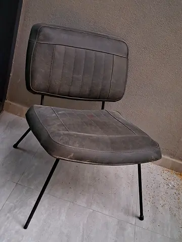 Vintage industrial-style metal frame chair with faux leather seat and back