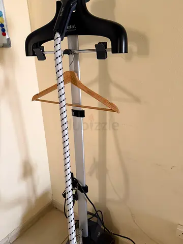 Wall-mounted clothes hanger with extendable rod and wooden hangers