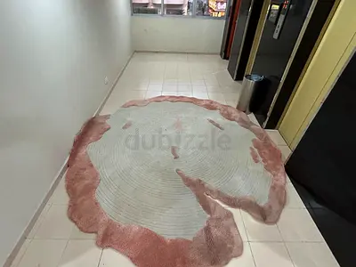 Round abstract pink and beige area rug — good condition needs to cleaned made of new Zealand wool