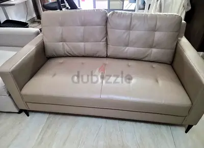 Two-seater beige leather sofa in good condition