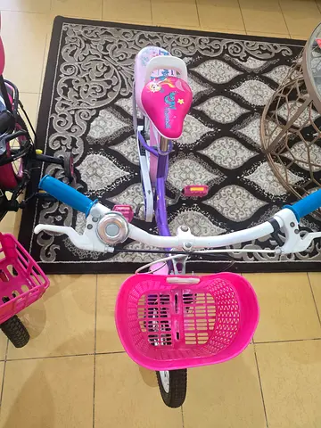 Kids purple bicycle with training wheels and front basket